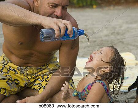 Father playing with young daughter at beach View Large Photo Image Stock Image - Father playing with young daughter at beach. Fotosearch