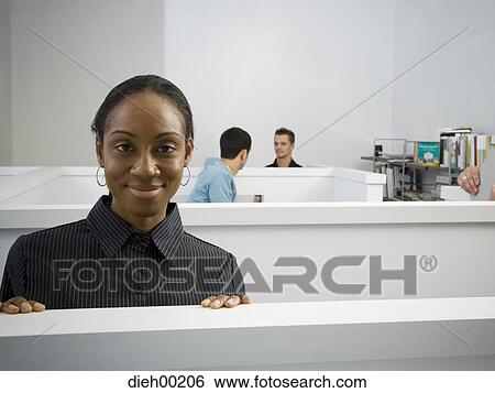 Stock Photograph - Female African-American office worker in office cubicle. Fotosearch