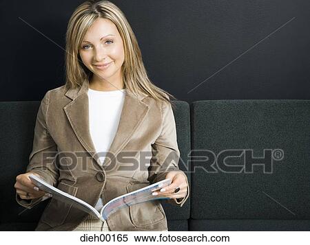 Stock Photography - Female office worker reading a magazine. Fotosearch