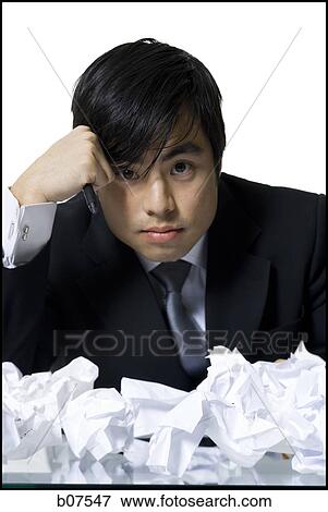 Frustrated businessman surrounded by crumpled papers View Large Photo Image Stock Photo - Frustrated businessman surrounded by crumpled papers. Fotosearch