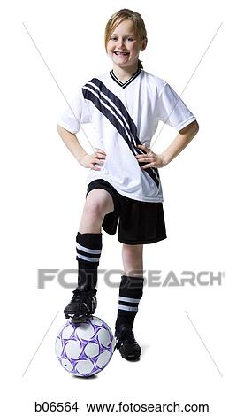 Picture - Girl in soccer uniform with foot on ball. Fotosearch