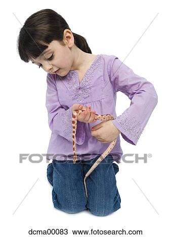 Stock Image - Girl playing with pet snake. Fotosearch