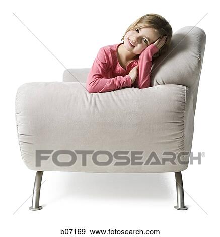 Girl sitting on couch View Large Photo Image Stock Photo - Girl sitting on couch. Fotosearch