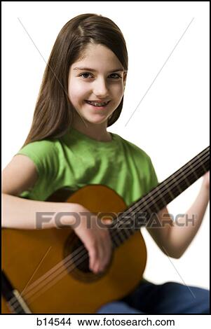 Picture - Girl with braces playing guitar smiling. Fotosearch