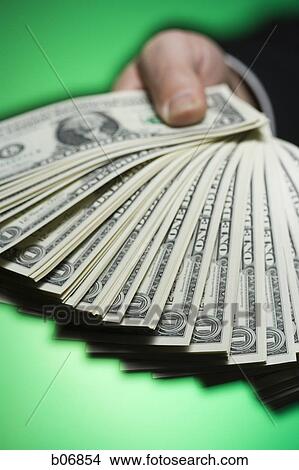 Hand extending fanned out US dollar bills View Large Photo Image Picture - Hand extending fanned out US dollar bills. Fotosearch