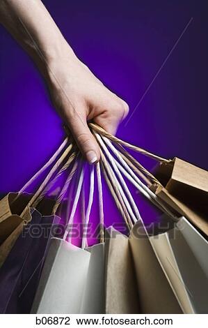 Hand grabbing several paper shopping bags View Large Photo Image Stock Image - Hand grabbing several paper shopping bags. Fotosearch