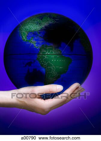 Stock Image - Hand holding earth globe in palm. Fotosearch