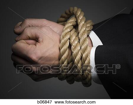 Hands tied at the wrists with rope View Large Photo Image Stock Photo - Hands tied at the wrists with rope. Fotosearch