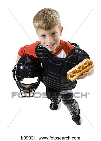Stock Image - High angle view of a baseball catcher holding a baseball helmet. Fotosearch