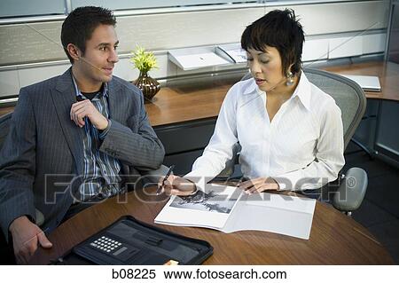 High angle view of a businessman and a businesswoman in a meeting View Large Photo Image Stock Photography - High angle view of a businessman and a businesswoman in a meeting. Fotosearch