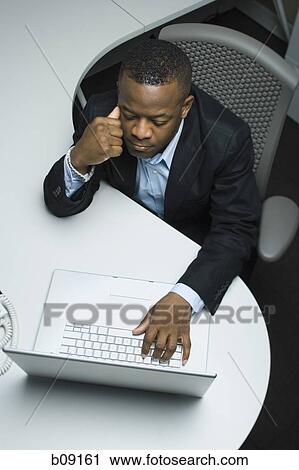High angle view of a businessman using a laptop View Large Photo Image Stock Image - High angle view of a businessman using a laptop. Fotosearch