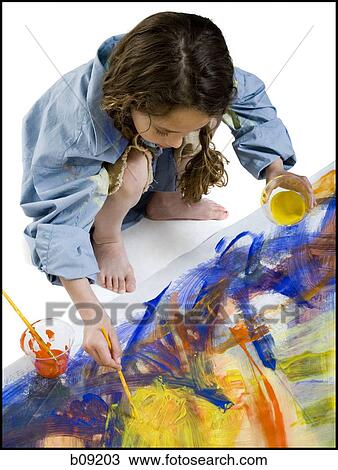 Stock Image - High angle view of a girl painting on the floor. Fotosearch