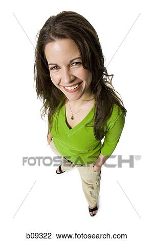 Stock Image - High angle view of a mid adult woman standing with her hands in her pockets. Fotosearch