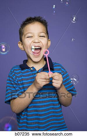 Little boy laughing and blowing bubbles View Large Photo Image Stock Photography - Little boy laughing and blowing bubbles. Fotosearch