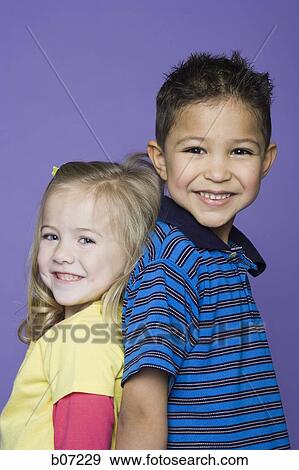 Little girl and boy back to back smiling View Large Photo Image Stock Photo - Little girl and boy back to back smiling. Fotosearch