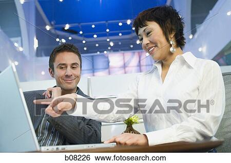 Stock Photograph - Low angle view of a businessman and a businesswoman talking. Fotosearch