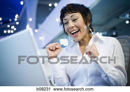 Low angle view of a businesswoman laughing in front of a laptop View Large Photo Image Stock Image - Low angle view of a businesswoman laughing in front of a laptop. Fotosearch