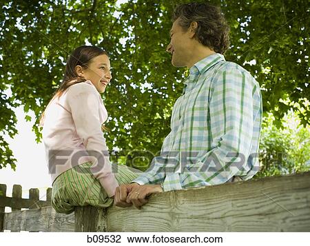 Low angle view of a man and his daughter smiling View Large Photo Image Stock Image - Low angle view of a man and his daughter smiling. Fotosearch