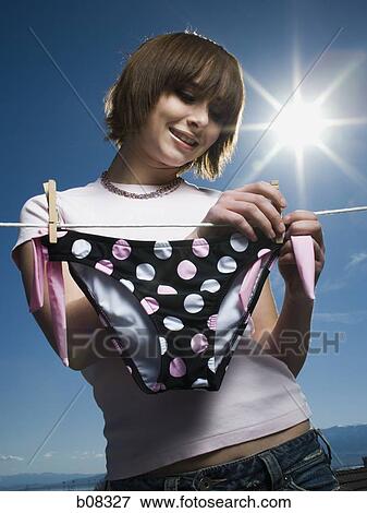 Low angle view of a teenage girl drying a bikini bottom on a clothesline View Large Photo Image Stock Photo - Low angle view of a teenage girl drying a bikini bottom on a clothesline. Fotosearch