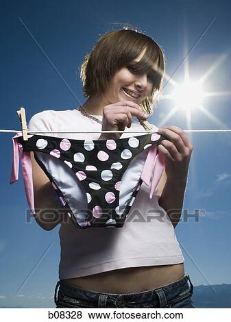 Low angle view of a teenage girl drying a bikini bottom on a clothesline View Large Photo Image Stock Photo - Low angle view of a teenage girl drying a bikini bottom on a clothesline. Fotosearch