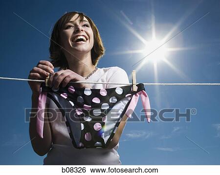 Low angle view of a teenage girl drying a bikini bottom on a clothesline View Large Photo Image Stock Photograph - Low angle view of a teenage girl drying a bikini bottom on a clothesline. Fotosearch