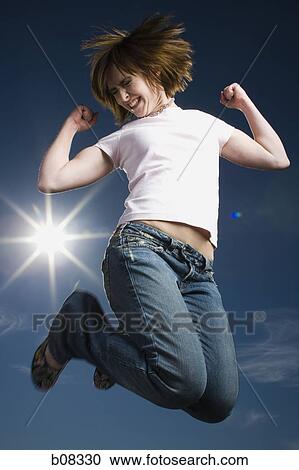Low angle view of a teenage girl jumping View Large Photo Image Stock Image - Low angle view of a teenage girl jumping. Fotosearch