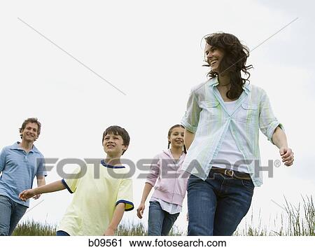 Stock Image - Low angle view of a woman and a man with their son and daughter in a field. Fotosearch