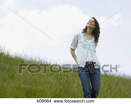 Low angle view of a woman laughing in a field View Large Photo Image Picture - Low angle view of a woman laughing in a field. Fotosearch