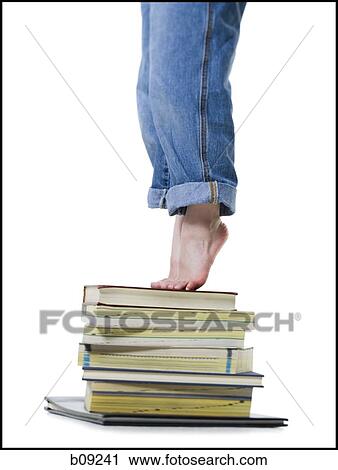 Low section view of a girl standing on a stack of books View Large Photo Image Stock Image - Low section view of a girl standing on a stack of books. Fotosearch