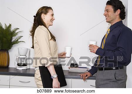 Stock Photo - Male and female business colleagues on coffee break. Fotosearch