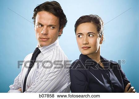Male and female business colleagues standing back to back View Large Photo Image Stock Photo - Male and female business colleagues standing back to back. Fotosearch