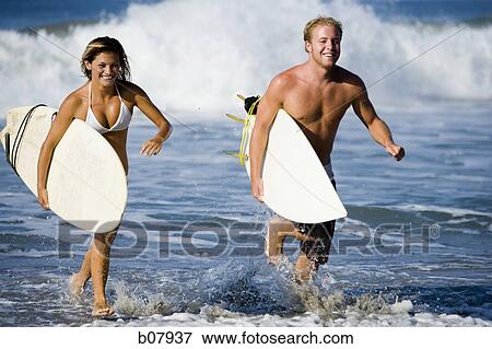 Stock Photo - Male and female surfers. Fotosearch