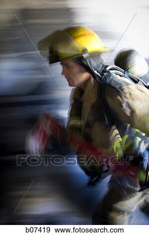 Male firefighter in action View Large Photo Image Stock Photo - Male firefighter in action. Fotosearch