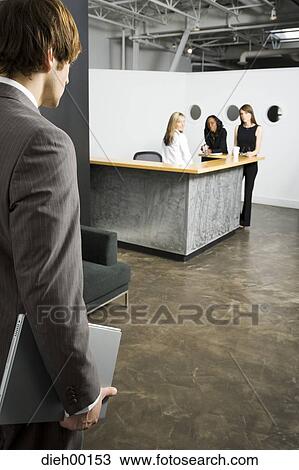 Male office worker arriving for meeting holding laptop View Large Photo Image Stock Image - Male office worker arriving for meeting holding laptop. Fotosearch