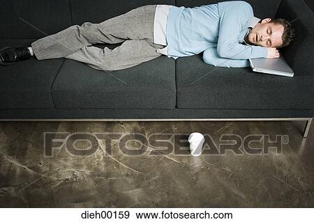 Stock Photo - Male office worker napping on chair. Fotosearch