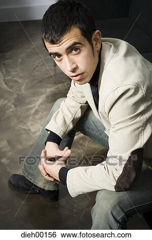 Male office worker sitting and posing View Large Photo Image Stock Photograph - Male office worker sitting and posing. Fotosearch