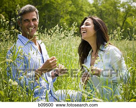 man and a woman laughing in a field View Large Photo Image Stock Image - man and a woman laughing in a field. Fotosearch