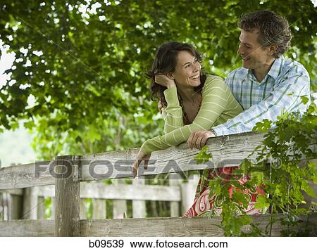 man and a woman leaning on a wooden fence View Large Photo Image Stock Photo - man and a woman leaning on a wooden fence. Fotosearch