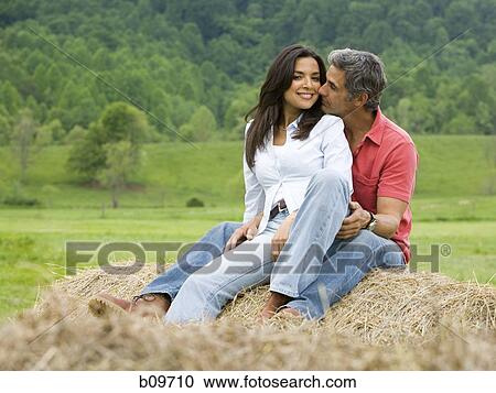 man and a woman sitting on a hay bale View Large Photo Image Stock Image - man and a woman sitting on a hay bale. Fotosearch