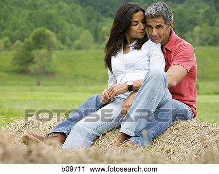 man and a woman sitting on a hay bale View Large Photo Image Stock Image - man and a woman sitting on a hay bale. Fotosearch