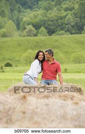 man and a woman sitting on a hay bale View Large Photo Image Stock Photography - man and a woman sitting on a hay bale. Fotosearch