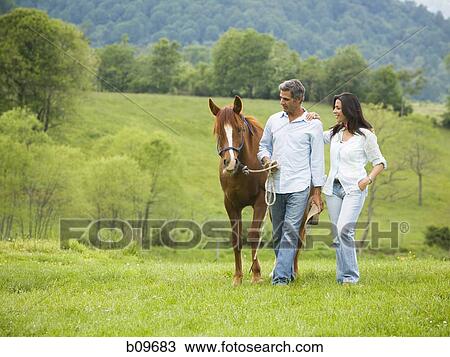 man and a woman walking with a horse View Large Photo Image Stock Image - man and a woman walking with a horse. Fotosearch