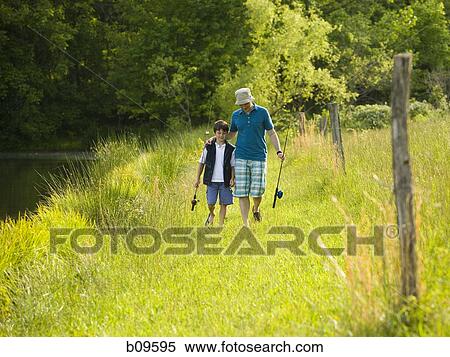 Stock Photography - man and his son holding fishing rods and walking in a forest. Fotosearch