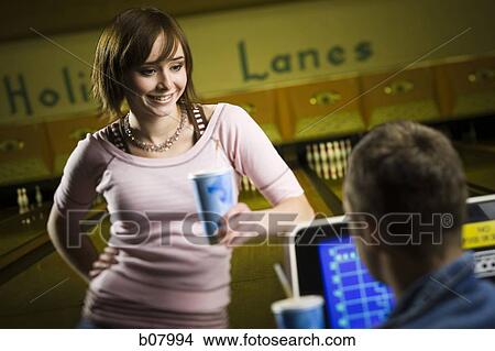 Picture - Man and woman talking at bowling alley. Fotosearch