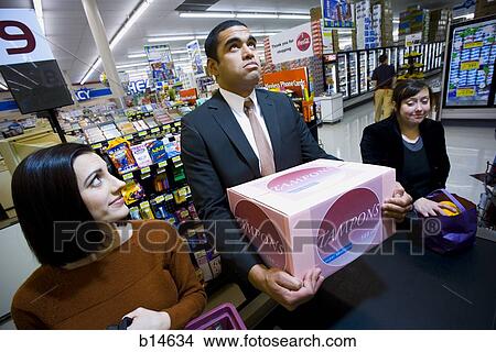 Man at grocery checkout with box of tampons and two women View Large Photo Image Picture - Man at grocery checkout with box of tampons and two women. Fotosearch