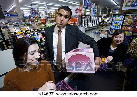 Man at grocery checkout with box of tampons and two women View Large Photo Image Stock Photo - Man at grocery checkout with box of tampons and two women. Fotosearch