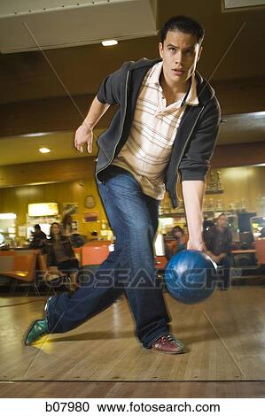 Stock Image - Man bowling in alley. Fotosearch