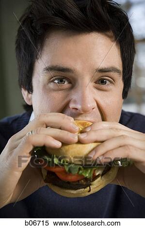 Man eating hamburger View Large Photo Image Stock Photography - Man eating hamburger. Fotosearch