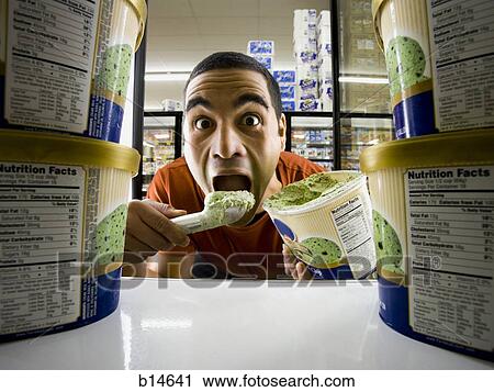 Man eating ice cream at grocery store View Large Photo Image Stock Image - Man eating ice cream at grocery store. Fotosearch