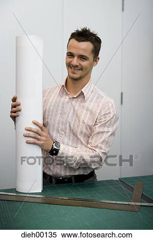Stock Photography - Man holding rolled blueprints. Fotosearch
